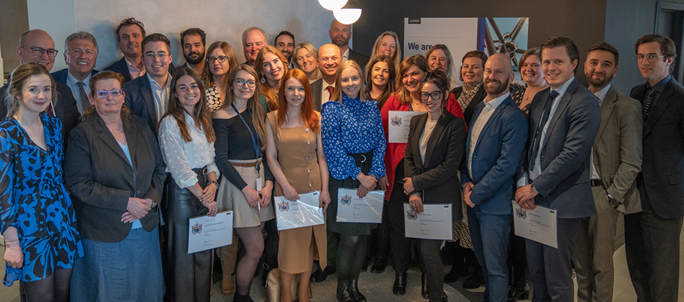 The group are smiling and holding their certificates 