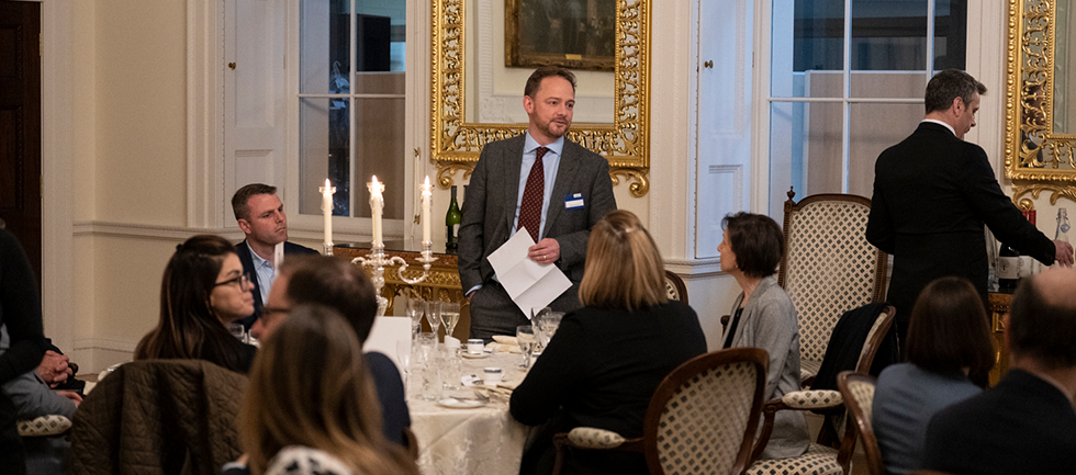 Man is stood speaking to the people seated in the Adam Room
