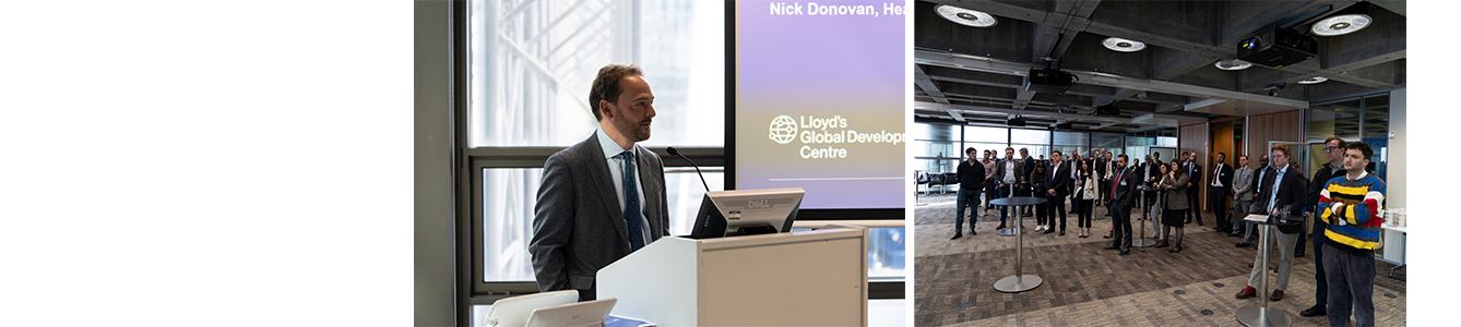 Delegates stand around a large events room in the Lloyd's building, they are all facing the same direction listening to one of the speakers