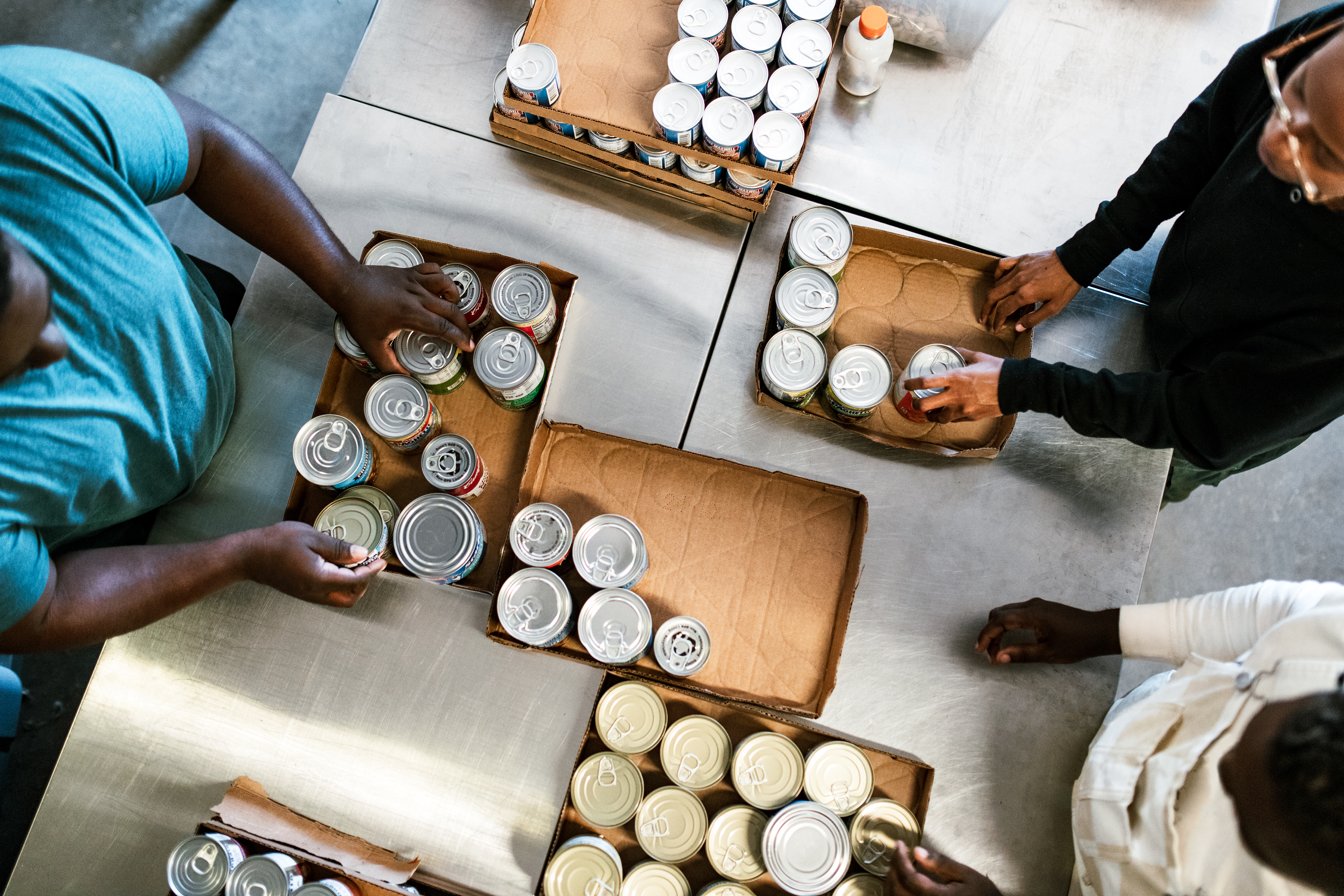 People packing tins of food into boxes