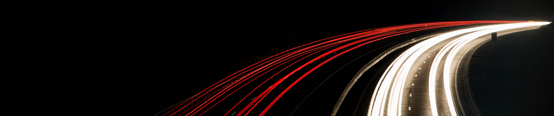 Vehicles driving on a road in the dark