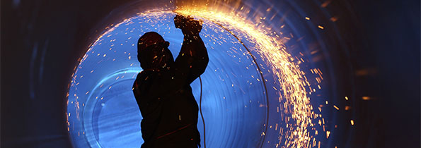 A worker using a angle grinder creating sparks