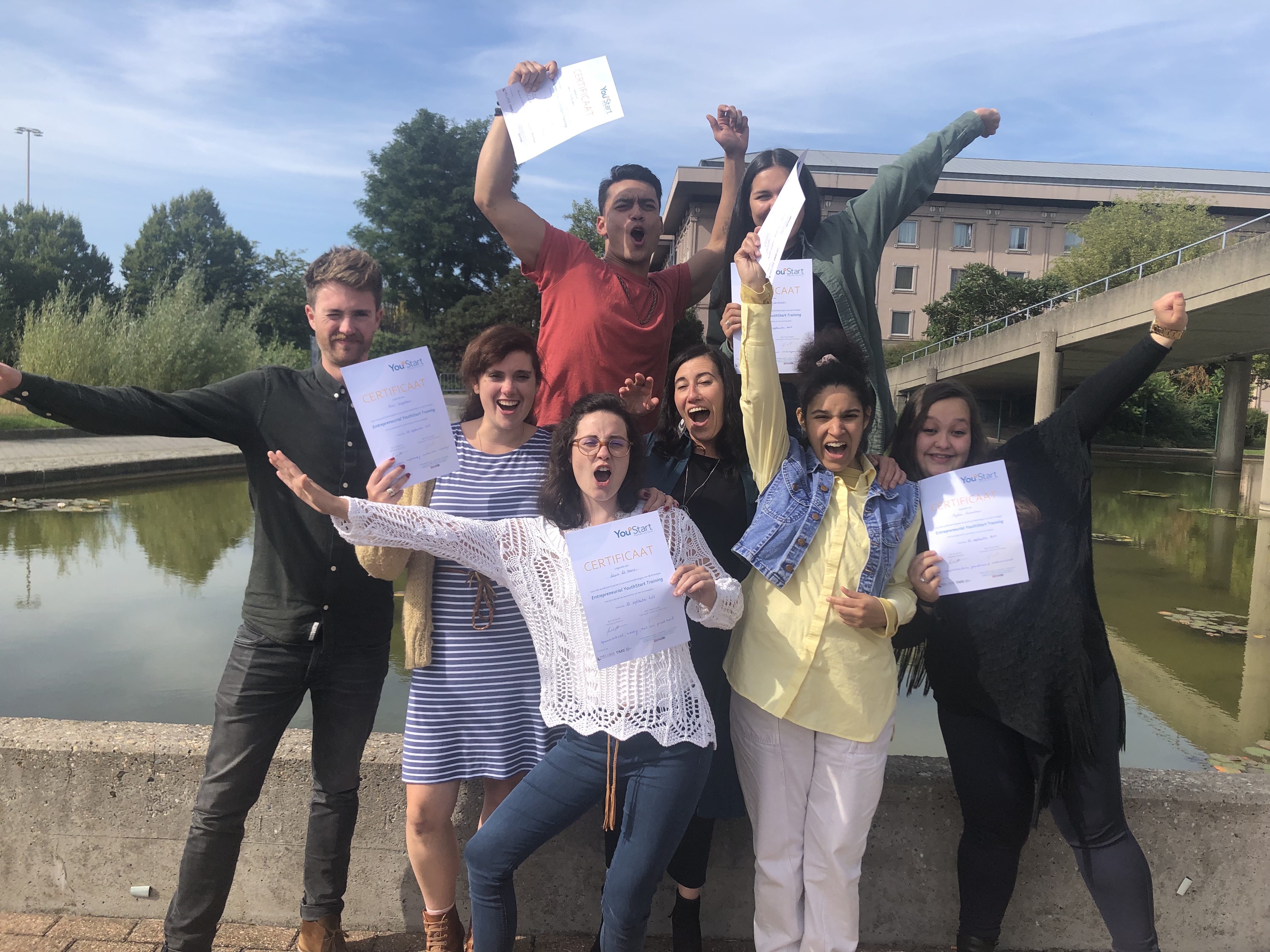 A group of people celebrating and holding up certificates