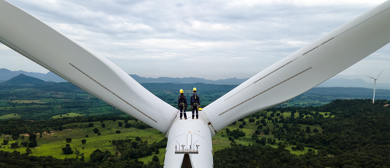 Workers standing on a wind turbine