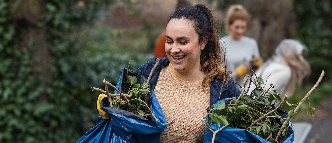 A volunteer carrying garden waste